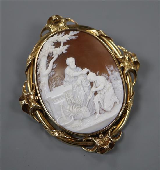 A late Victorian scrolling yellow metal mounted oval cameo brooch, carved with St John the Baptist, 82mm.